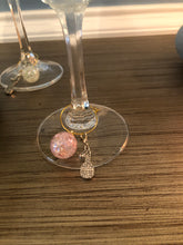 Load image into Gallery viewer, A light pink Pickleball Wine Glass Charm on a glass